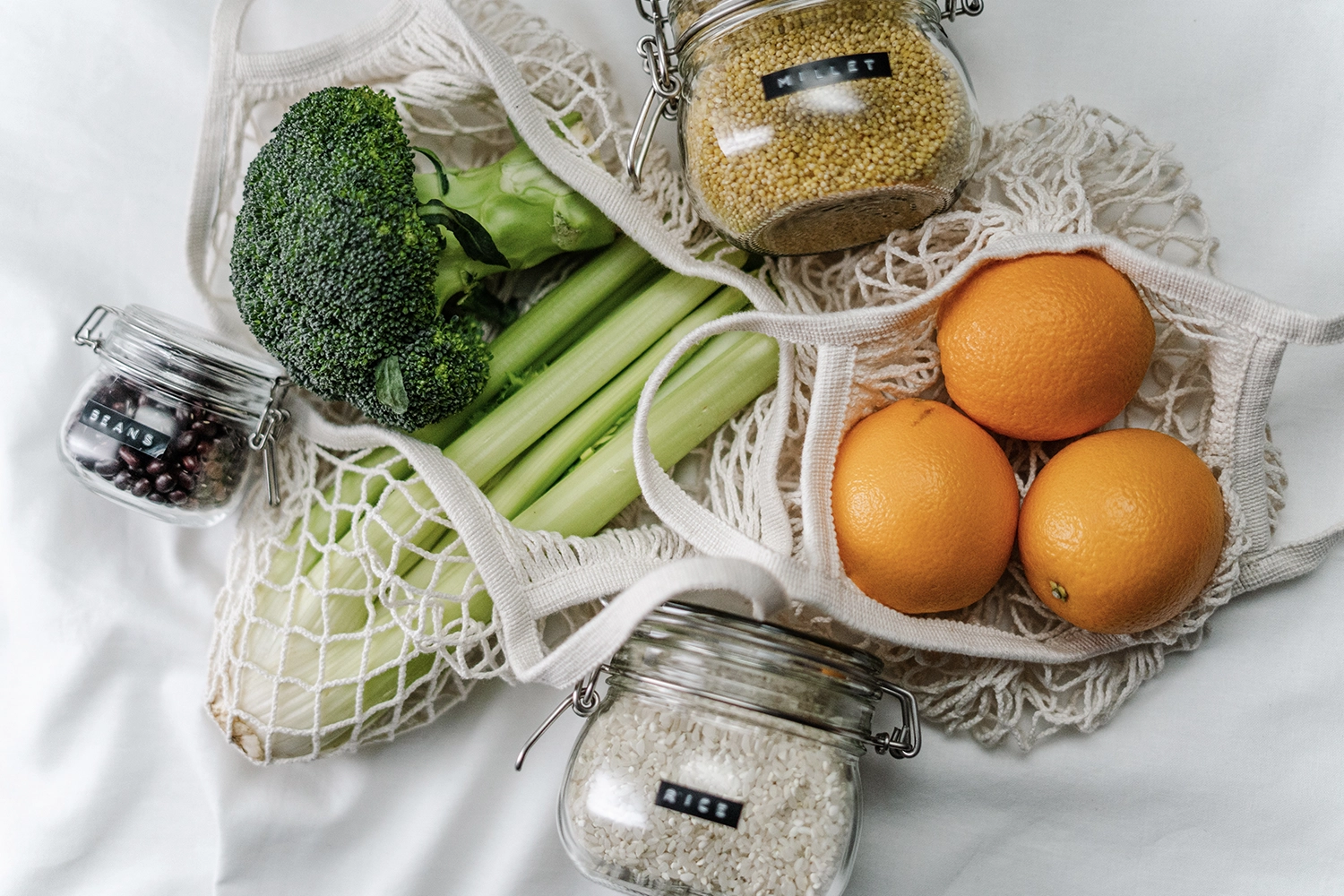 variety of grains in glass jars and fruits and vegetables in bags